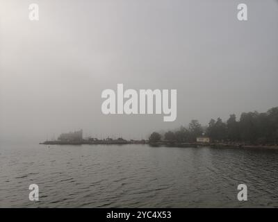 Entspannende nebelige Herbstszene im Norden mit Badeplattform, Ponton oder Holzpier mit einer Stahlleiter in die Ostsee. Herbstferien in Stockfoto