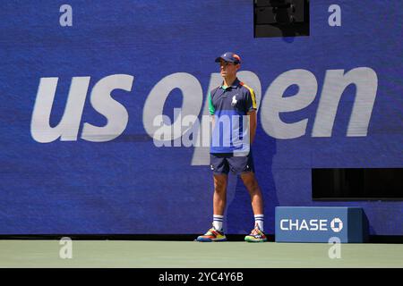 Ballboy steht auf dem Platz vor dem US Open Logo während eines Spiels bei den US Open 2024 Championships, Billie Jean King Tennis Center, Queens, New Yor Stockfoto