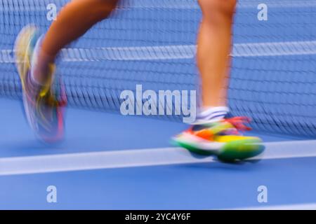 Verschwommene Beine eines Ballmädchens während eines Spiels bei den US Open 2024 Championships, Billie Jean King Tennis Center, Queens, New York, USA. Stockfoto