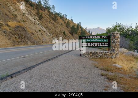 Ein hölzernes Schild begrüßt Besucher in Kernville, Kalifornien. Das Schild erwähnt das Rock & Blues fest im September und liegt neben der Hauptstraße. Stockfoto