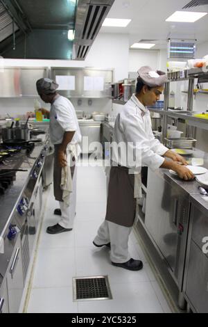 Randheli, Malediven - 07. März 2014: Zwei maledivische Köche arbeiten in einer Küche und bereiten Mahlzeiten vor. Stockfoto