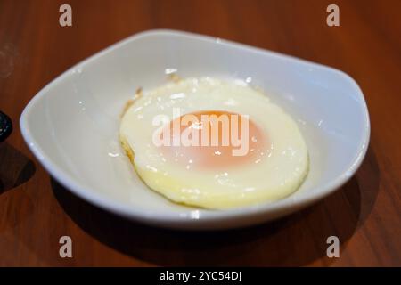 Spiegelei in weißer Schüssel auf Holztisch Stockfoto