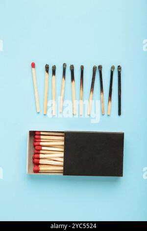 Verbrannte Streichhölzer auf Blau. Verschiedene Stadien der verbrannten Streichhölzer. Volle Schärfentiefe. Draufsicht Stockfoto