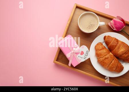 Froher Muttertag, wunderschönes Frühstück, Mittagessen mit einer Tasse Kaffee, frischen Croissants, Tulpe und Geschenk. Frühlingsferien, Familienbeziehungen. Draufsicht Stockfoto