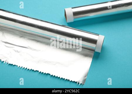 Rollen aus Aluminiumfolie auf blauem Hintergrund. Draufsicht Stockfoto