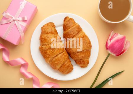 Froher Muttertag, wunderschönes Frühstück, Mittagessen mit einer Tasse Kaffee, frischen Croissants, Tulpe und Geschenk. Frühlingsferien, Familienbeziehungen. Draufsicht Stockfoto