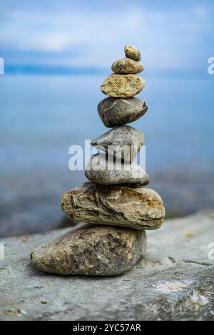 Ein Steinhaufen auf einem Felsen am Wasser. Die Felsen sind pyramidenförmig angeordnet. Die Szene ist friedlich und ruhig, mit dem Wasser und den Felsen Kreatin Stockfoto