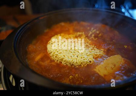 Sofortramen in die Kimchi-Eintopfbrühe geben und kochen Stockfoto