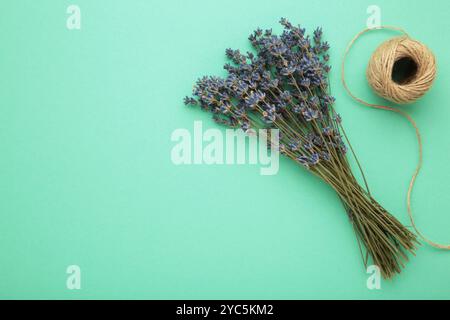 Kleines Bouquet eines getrockneten Lavendels auf Minzhintergrund. Draufsicht Stockfoto