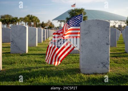 Amerikanischer nationaler Militärfriedhof mit Reihen weißer Grabsteine und US-Flagge auf grünem Rasen. Memorial Day-Konzept. Stockfoto