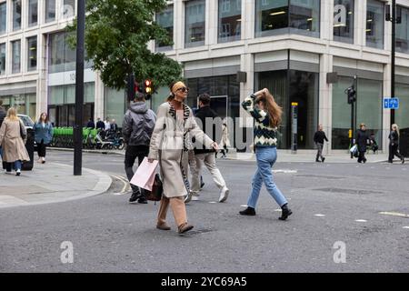 Eine Dame in modischer Kleidung spaziert entlang Cheapside, im Herzen der City of London, England, Großbritannien Stockfoto