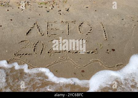 Die Inschrift Sommer 2022 auf dem nassen Sand des Meeresstrandes. Stockfoto