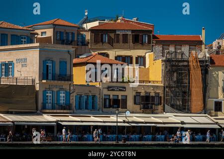 Ein lebhafter Blick auf traditionelle Gebäude entlang der Uferpromenade des alten venezianischen Hafens in Chania, Kreta. Die Fassaden dieser historischen Häuser zeigen Stockfoto