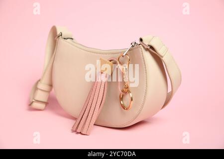 Tasche mit Schlüsselanhänger aus Leder auf rosa Hintergrund, Nahaufnahme Stockfoto