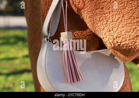 Frau mit rosa Leder Schlüsselanhänger an ihrer Tasche draußen, Nahaufnahme Stockfoto