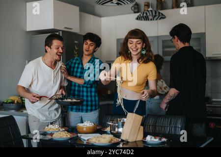 Freunde genießen ein Pasta-Abendessen in einer gemütlichen Küche Stockfoto