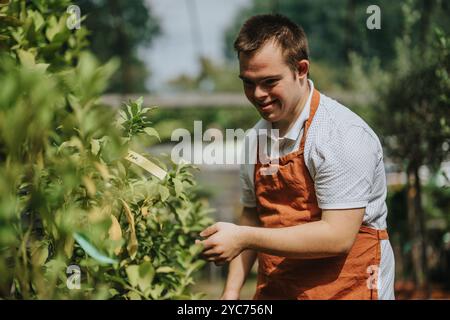 Junger Gärtner mit Down-Syndrom, der Pflanzen im Sonnenschein pflegt Stockfoto