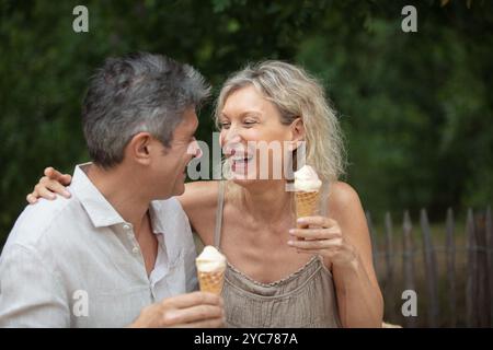 Glückliches, reifes Paar, das ein Eis im Park isst Stockfoto