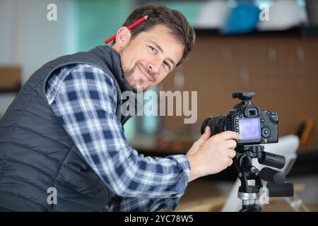 miling bärtiger Handwerker mit dslr Stockfoto