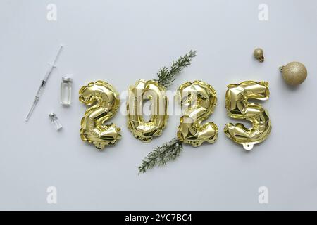 Abbildung 2025 mit medizinischem Zubehör und Weihnachtsdekor auf grauem Hintergrund Stockfoto
