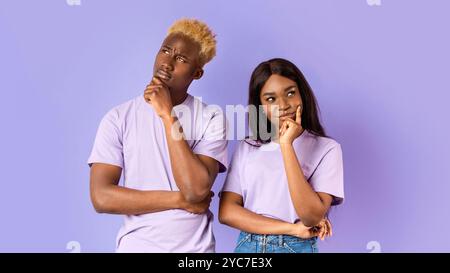 Schwarze Dame und Kerl, tief in Gedanken über Flieder Hintergrund Stockfoto