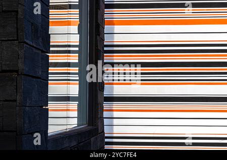 Wand mit orangefarbenen, weißen, schwarzen Linien und Texturen. Textur. Lackierte Wand Stockfoto