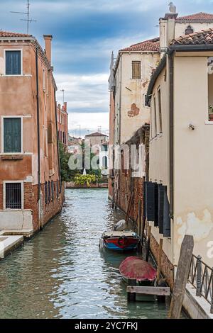 Enge Kanalstraße mit alten Gebäuden Fassaden in Venedig Stockfoto