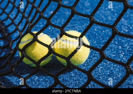 Zwei Bälle hinter dem Netz auf einem Paddeltennisplatz, Hintergrundkonzept für Racketsport Stockfoto