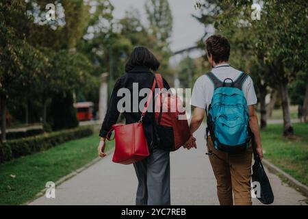 Ein Paar, das Hand in Hand durch einen malerischen Park-Pfad geht Stockfoto