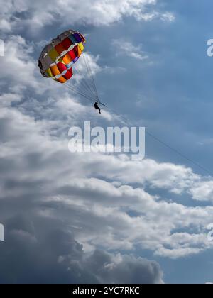 Silhouette eines Mannes, der in einem blauen Himmel Parasailing. Stockfoto