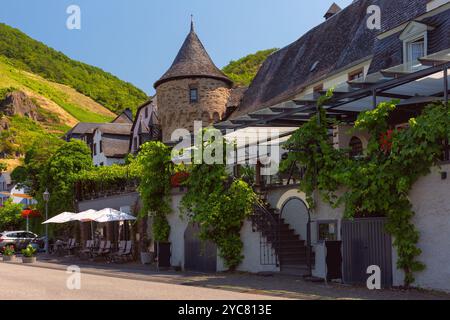 Ein historisches Haus mit einem Steinturm und einer Terrasse mit Weinreben in Beilstein, Deutschland Stockfoto