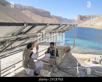 Der Gewinner des Umweltfotowettbewerbs #9 USAID unterstützt die Elektrifizierung ländlicher Schulen in Afghanistan durch Projekte wie das Afghanistan Clean Energy Program (ACEP). ACEP schuf eine 2 kW-Solaranlage, um die Shaheed Mahmoodi High School im Band-e Amir Nationalpark in der Provinz Bamiyan mit Strom zu versorgen 621. Hier beenden afghanische Techniker die Installation und Prüfung der Solaranlage. Foto: USAID / Robert Foster, Winrock International Stockfoto