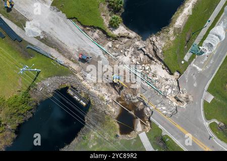 Wiederaufbau einer beschädigten Straßenbrücke, die durch den Fluss zerstört wurde, nachdem das Wasser Asphalt weggespült hatte. Wiederaufbau der zerstörten Verkehrsinfrastruktur. Stockfoto