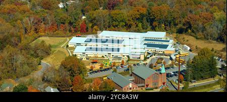 Dach des amerikanischen Schulgebäudes mit Photovoltaik-Solarpaneelen für die Stromerzeugung. Konzept für erneuerbare Energien. Stockfoto