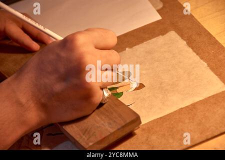 Dieses fesselnde Bild zeigt die geschickten Hände einer handwerklichen Holzmalerei auf einem der pulsierenden Basare von Buchara, Usbekistan. Stockfoto