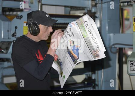 GREYMOUTH, NEUSEELAND, 22. MAI 2015: Ein nicht identifizierter Drucker prüft die Qualität seiner Verarbeitung, während er am 22. Mai 2015 eine Zeitung in Grey druckte Stockfoto