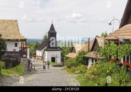 Besucher schlendern entlang der Kossuth Straße im UNESCO-Weltkulturerbe-Dorf Holloko, Ungarn, Europa Stockfoto