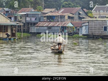 Ein Mann rudert mit seinem kleinen Holzboot über den Bassac River, Chau Doc, Vietnam, Asien Stockfoto