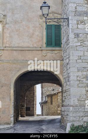 Eine alte Straßenlaterne und ein geschlossener Rolltor über dem Torbogen zur Villa A SESTA in Chianti, Toskana, Italien, Europa Stockfoto