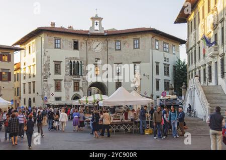 Einheimische und Touristen besuchen das kleine Bazar vor Palazzo Orologio auf Ritter Platz (Piazza dei Cavalieri), der zweite Haupt Platz von Pisa Stockfoto