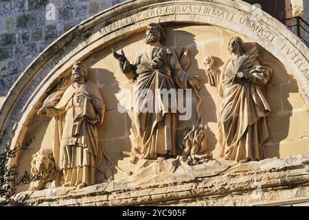 Relief auf der Rückseite des Haupttors mit den Schutzheiligen von Malta: St. Paul in der Mitte mit St. Publius und St. Agatha an seinen Seiten, Mdina Stockfoto