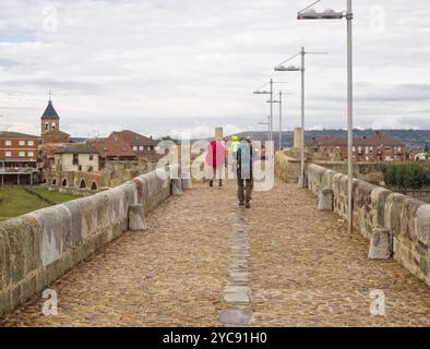 Pilger gehen auf der mittelalterlichen Brücke aus dem 13. Jahrhundert über den Fluss Orbigo, Hospital de Orbigo, Kastilien und Leon, Spanien, Europa Stockfoto