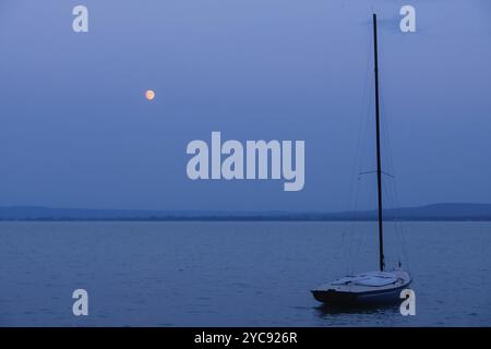 Kleines Segelboot, das unter dem Mond auf dem Balaton, Revfulop, Ungarn, Europa vor Anker liegt Stockfoto