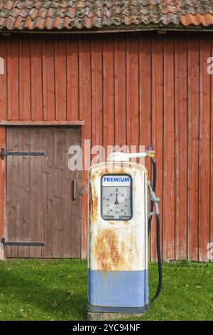 Alte, rostige Gaspumpe bei einer roten Scheune Stockfoto