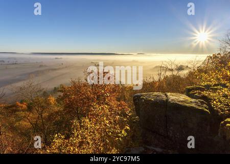 Die Sonne scheint über ein Tal mit Nebel im Herbst Stockfoto