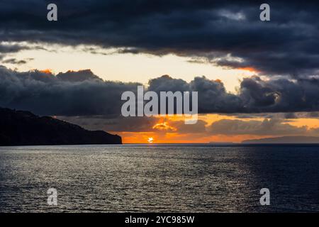 Sonnenaufgang und stürmische Wolken über dem Hafen von Funchal, Madeira, Portugal Stockfoto