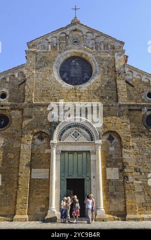 Eine Gruppe von Touristen vor der romanisch-pisanischen Fassade der Kathedrale, die der Himmelfahrt der Jungfrau Maria gewidmet ist, Volterra, Toskana, Italien Stockfoto