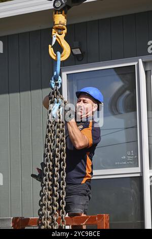 GREYMOUTH, NEUSEELAND, 21. OKTOBER 2020: Ein Kranführer arbeitet daran, ein kleines Gebäude von einem Lkw auf seine Pfeile zu heben Stockfoto