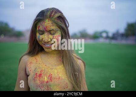 Glückliche junge indianerin bedeckt mit farbenfrohem Pulver oder gulal, die das holi-Festival der Farben feiert. Kultur indiens. Stockfoto