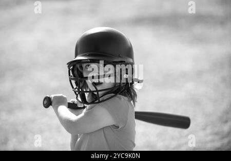 Der kleine blonde Junge mit Gesichtsausdruck hält einen Baseballschläger. Stockfoto